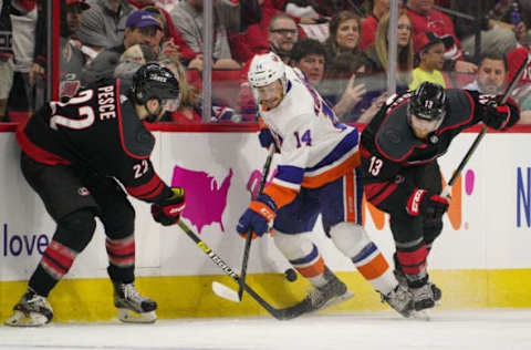 RALEIGH, NC – MAY 03: Carolina Hurricanes defenseman Brett Pesce (22) and Carolina Hurricanes left wing Warren Foegele (13) battle New York Islanders right wing Tom Kuhnhackl (14) for a puck during a game between the Carolina Hurricanes and the New York Islanders on March 3, 2019 at the PNC Arena in Raleigh, NC. (Photo by Greg Thompson/Icon Sportswire via Getty Images)