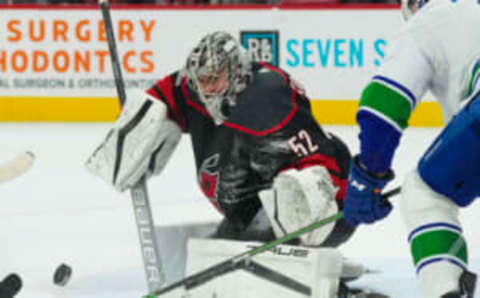 Jan 15, 2023; Raleigh, North Carolina, USA; Carolina Hurricanes goaltender Pyotr Kochetkov (52) makes save against Vancouver Canucks center J.T. Miller (9) during the overtime at PNC Arena. Mandatory Credit: James Guillory-USA TODAY Sports