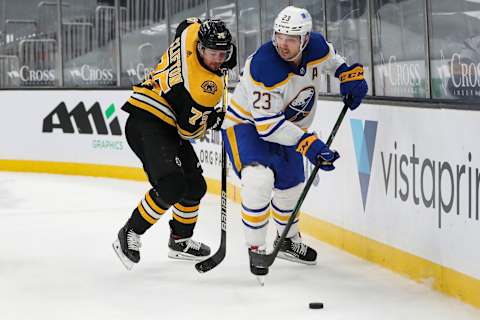 BOSTON, MA – APRIL 13: Sam Reinhart #23 of the Buffalo Sabres and Connor Clifton #75 of the Boston Bruins battle for a puck in overtime at TD Garden on April 13, 2021 in Boston, Massachusetts. (Photo by Adam Glanzman/Getty Images)