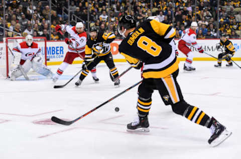 PITTSBURGH, PA – MARCH 31: Pittsburgh Penguins Defenseman Brian Dumoulin (8) passes the puck as Pittsburgh Penguins Right Wing Bryan Rust (17) and Carolina Hurricanes Left Wing Nino Niederreiter (21) battle in front of Carolina Hurricanes Goalie Curtis McElhinney (35) during the second period in the NHL game between the Pittsburgh Penguins and the Carolina Hurricanes on March 31, 2019, at PPG Paints Arena in Pittsburgh, PA. (Photo by Jeanine Leech/Icon Sportswire via Getty Images)