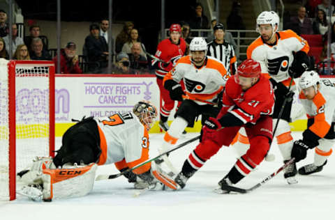 RALEIGH, NC – NOVEMBER 21: Nino Niederreiter #21 of the Carolina Hurricanes takes a shot on goal as Brian Elliott #37 of the Philadelphia Flyers goes down in the crease and make a pad save during an NHL game on November 21, 2019 at PNC Arena in Raleigh, North Carolina. (Photo by Gregg Forwerck/NHLI via Getty Images)