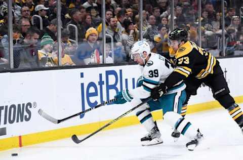 Jan 22, 2023; Boston, Massachusetts, USA; San Jose Sharks center Logan Couture (39) and Boston Bruins defenseman Charlie McAvoy (73) battle for the puck during the second period at TD Garden. Mandatory Credit: Bob DeChiara-USA TODAY Sports