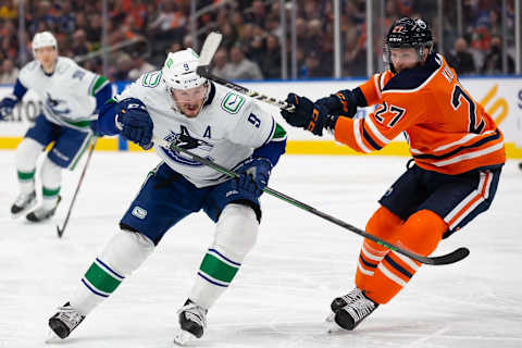 EDMONTON, AB – APRIL 29: Brett Kulak #27 of the Edmonton Oilers high sticks J.T. Miller #9 of the Vancouver Canucks during the first period at Rogers Place on April 29, 2022 in Edmonton, Canada. (Photo by Codie McLachlan/Getty Images)