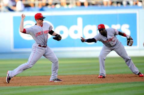 July 27, 2013; Los Angeles, CA, USA; Cincinnati Reds shortstop Zack Cozart (2) throws to first after second baseman Brandon Phillips (4) tosses the ball to him during the second inning against the Los Angeles Dodgers at Dodger Stadium. Mandatory Credit: Gary A. Vasquez-USA TODAY Sports