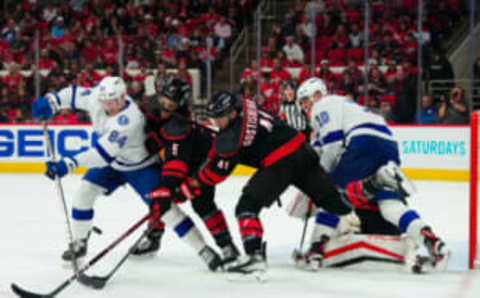 Mar 28, 2023; Raleigh, North Carolina, USA; Tampa Bay Lightning left wing Tanner Jeannot (84) and right wing Corey Perry (10) battle for a loose puck against Carolina Hurricanes defenseman Jalen Chatfield (5) and defenseman Shayne Gostisbehere (41) during the second period at PNC Arena. Mandatory Credit: James Guillory-USA TODAY Sports