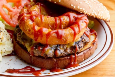 hamburger with onion rings and barbeque sauce