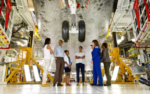 President Obama and the First Family stand beneath the Space Shuttle Atlantis prior to its final flight.