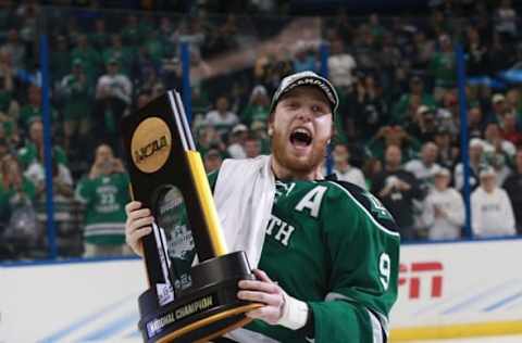 Apr 9, 2016; Tampa, FL, USA; North Dakota Fighting Hawks forward Drake Caggiula (9) skates around with the trophy after beating the Quinnipiac Bobcats in the championship game of the 2016 Frozen Four college ice hockey tournament at Amalie Arena. North Dakota defeated Quinnipiac 5-1. Mandatory Credit: Kim Klement-USA TODAY Sports