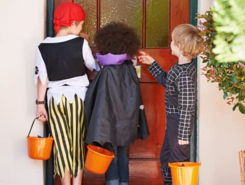 Kids knocking on a door in costume.