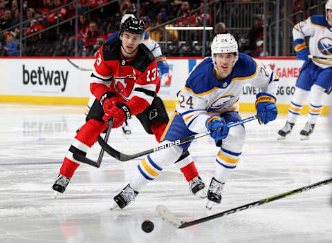 NEWARK, NEW JERSEY – APRIL 21: Nico Hischier #13 of the New Jersey Devils and Dylan Cozens #24 of the Buffalo Sabres cahse afte rthe puck during the third period at Prudential Center on April 21, 2022 in Newark, New Jersey. The Buffalo Sabres defeated the New Jersey Devils 5-2. (Photo by Elsa/Getty Images)