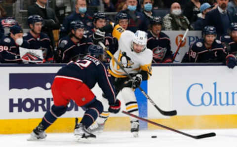 Jan 21, 2022; Columbus, Ohio, USA; Pittsburgh Penguins center Zach Aston-Reese (12) and Columbus Blue Jackets defenseman Jake Christiansen (32) battle for a loose puck during the first period at Nationwide Arena. Mandatory Credit: Russell LaBounty-USA TODAY Sports