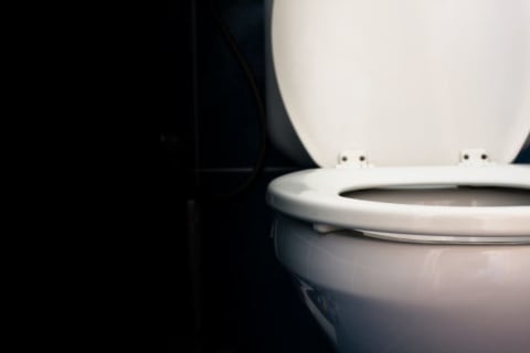 A toilet on a black background.