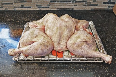 A spatchcocked turkey on a roasting rack.