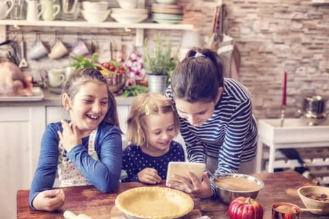 Three girls prepare a pumpkin pie according to a recipe.