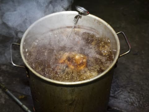 A turkey cooking in a hot fryer.