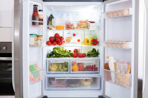 An open fridge full of fruits and vegetables.