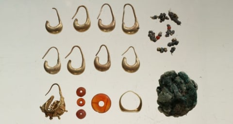 A 3100-year-old jewelry hoard, including earrings, beads, a ring, and silver jewelry wrapped in linen cloths.