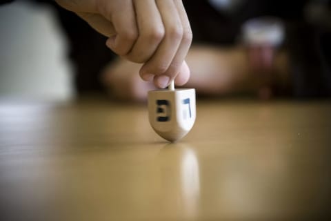 Child spinning a dreidel.