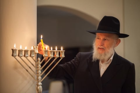 rabbi lighting a menorah