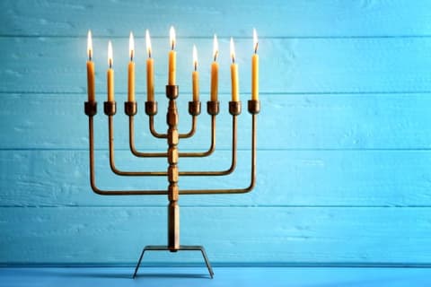 a geometric menorah against a blue background