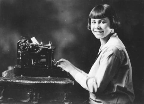 Woman sitting at a typewriter.