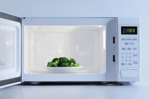 A bowl of broccoli in a microwave