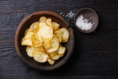 Chips in a bowl next to a small bowl of salt