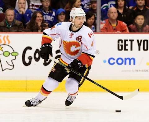 Feb 6, 2016; Vancouver, British Columbia, CAN; Calgary Flames defenseman Kris Russell (4) controls the puck against the Vancouver Canucks during the first period at Rogers Arena. The Calgary Flames won 4-1. Mandatory Credit: Anne-Marie Sorvin-USA TODAY Sports