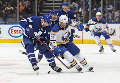 TORONTO, ON – APRIL 12: Vinnie Hinostroza #29 of the Buffalo Sabres battles for the puck against Morgan Rielly #44 of the Toronto Maple Leafs during an NHL game at Scotiabank Arena on April 12, 2022 in Toronto, Ontario, Canada. The Sabres defeated the Maple Leafs 5-2. (Photo by Claus Andersen/Getty Images)