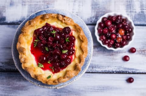 Cranberry pie with a bowl of cranberries beside it.