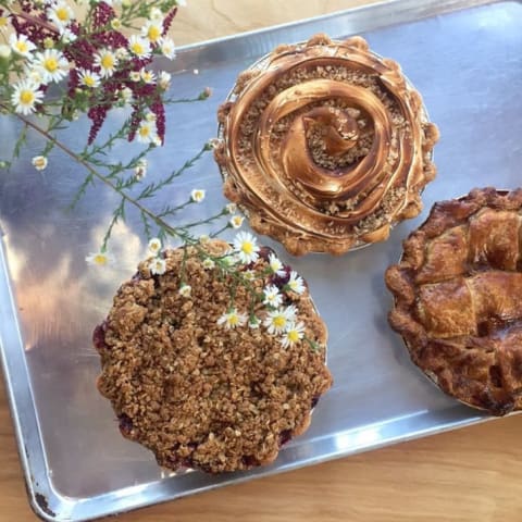 Three decorative pies on a tray.