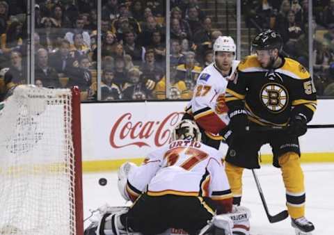 Mar 1, 2016; Boston, MA, USA; Calgary Flames goalie Joni Ortio (37) makes a save in front of defenseman Dougie Hamilton (27) and Boston Bruins center Ryan Spooner (51) during the third period at TD Garden. Mandatory Credit: Bob DeChiara-USA TODAY Sports