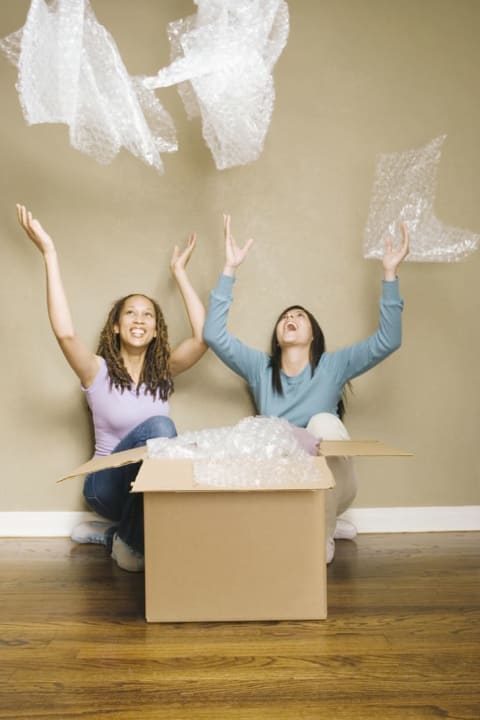 woman laughing and throwing bubble wrap