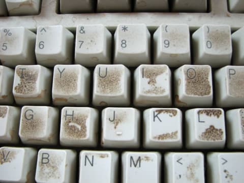 Closeup of keyboard keys covered in dirt and filth