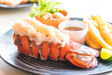 Lobster tail and dipping sauce on a plate