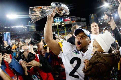 Mewelde Moore #21 of the Pittsburgh Steelers celebrates holds up the Vince Lombardi trophy as he celebrates with his daughter Jalyn Chantelle after their 27-23 win against the Arizona Cardinals during Super Bowl XLIII on February 1, 2009