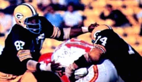 Green Bay Packers defensive linemen Willie Davis (left) and Henry Jordan (right) tackle Kansas City Chiefs quarterback Len Dawson (middle) in Super Bowl I.