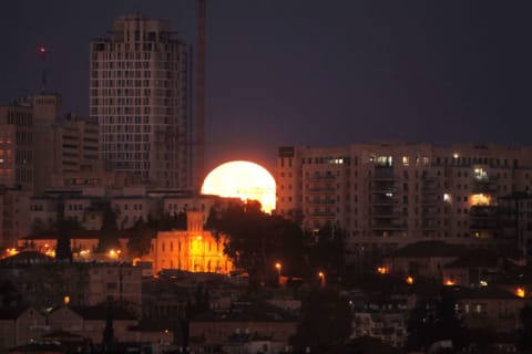 The moon sets behind the city of Jerusalem early on January 31, 2018.