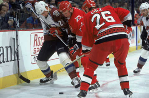 23 Oct 2001: Eric Messier #29 of the Colorado Avalanche fights for possession of the puck with Erik Cole #26 and Aaron Ward #4 of the Carolina Hurricanes during the game at the Pespi Center in Denver, Colorado. The Avalanche defeated the Hurricanes 5-1.Mandatory Credit: Brian Bahr /Allsport