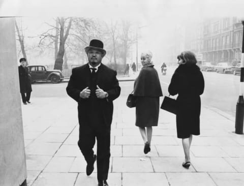 Professional wrestler and actor Toshiyuki 'Harold' Sakata wearing a suit and bowler hat, walking down a street in London, March 10th 1965.