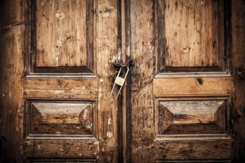 Heavy wooden doors locked in the middle with a padlock.