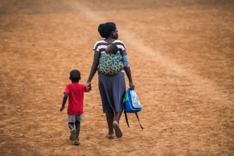 A woman walks with her child