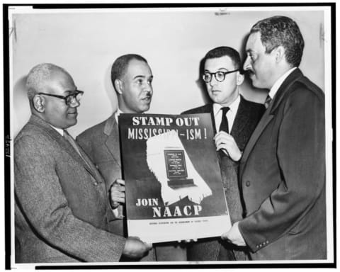 Marshall (far right) held up an NAACP sign with other leaders from the organization (from left to right) director of public relations Henry L. Moon, executive secretary Roy Wilkins, and labor secretary Herbert.