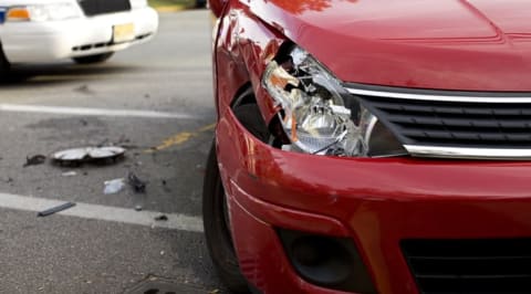 An image of a car with a broken headline after being in an accident.