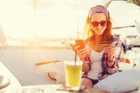 Woman whips out her credit card while hanging out on a hammock