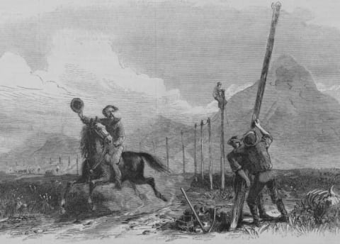 An illustration of a Pony Express rider passing men putting up telegraph poles, created in 1867.