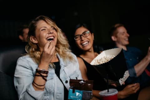 women laughing at a movie