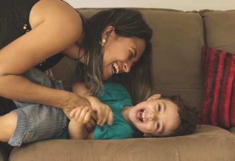 Mom and boy laughing on couch