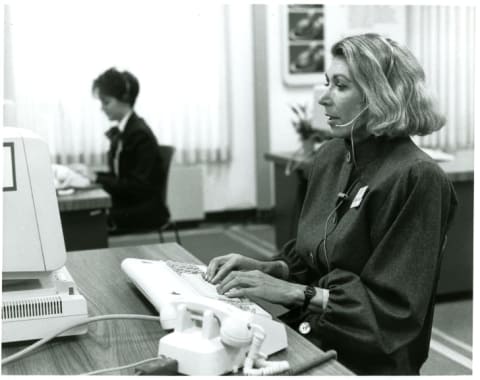 Two talk-line hosts answering calls at their desks in 1988.