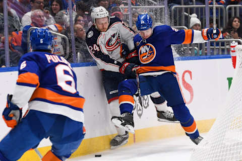 Dec 29, 2022; Elmont, New York, USA; New York Islanders defenseman Scott Mayfield (24) and Columbus Blue Jackets right wing Mathieu Olivier (24) battle behind the net during the third period at UBS Arena. Mandatory Credit: Dennis Schneidler-USA TODAY Sports